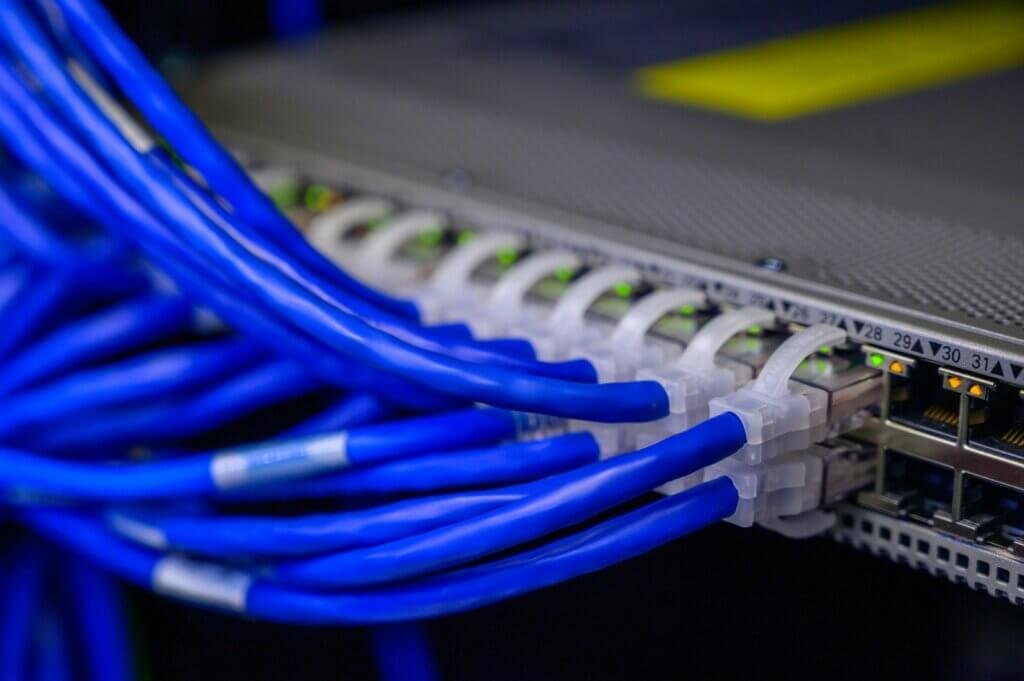 Kunskap som gör skillnad: guider för e-handel, drift och tillväxt En rad blå Ethernet-kablar kopplas in i en nätverksswitch i ett serverrum, med synliga indikatorlampor - för att fånga upp pulsen i e-handel och digital tillväxt.